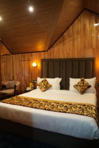 a bedroom with a large bed with wooden walls at Green Inn in Pahalgām