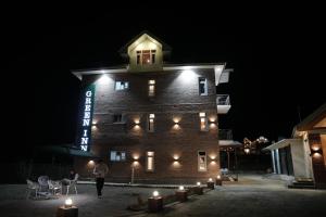 a woman standing in front of a building at night at Green Inn in Pahalgām
