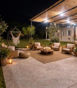 a patio at night with chairs and a table at Si Sofia country house in Capaccio-Paestum