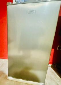 a metal refrigerator sitting on top of a floor at DeltaGateway selfcatering in Maun Airport