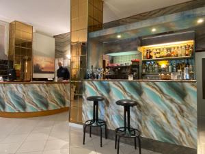 a bar with two stools in a room at Hotel Europa in Gabicce Mare