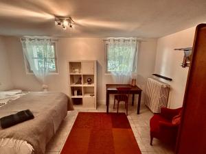 a bedroom with a bed and a table and a chair at Beaurivage, studio privé dans maison d'hôte avec parc in Libourne