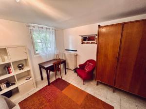 a living room with a desk and a red chair at Beaurivage, studio privé dans maison d'hôte avec parc in Libourne +18 photos