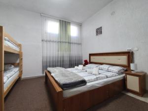 a bedroom with two beds and a window at White Apartment in Prizren