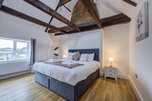 a bedroom with a large bed and a large window at Modern 1 Bed - Beams - Parking in Stamford