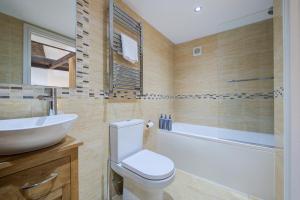 a bathroom with a toilet and a sink and a tub at Modern 1 Bed - Beams - Parking in Stamford