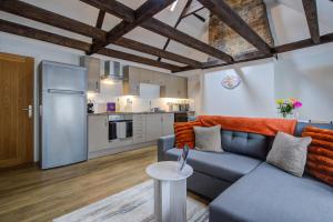 a living room with a blue couch and a kitchen at Modern 1 Bed - Beams - Parking in Stamford +26 photos
