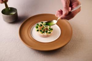 a person is eating a cupcake on a plate at Relais & Châteaux Taubenkobel in Schützen am Gebirge