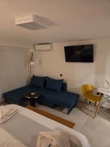 a living room with a blue couch and a tv at Cabo Verde in Agia Triada