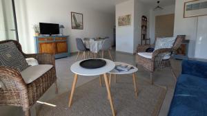 a living room with chairs and a table and a tv at Les Voiles du Clipper T2 in Préfailles