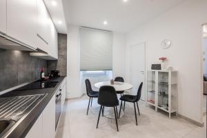 a white kitchen with a table and chairs at La Scaletta 10 min from train station for Cinque Terre! in La Spezia +16 photos