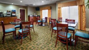 une salle à manger avec des tables et des chaises dans un restaurant dans l'établissement Best Western Plus Kalamazoo Suites, à Kalamazoo