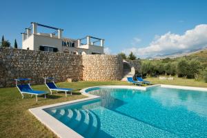 a pool with chairs and a house in the background at Collina Degli Ulivi B&B in Itri