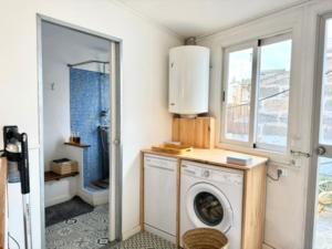 a laundry room with a washing machine and a window at Can PONÇ PARRA in Santanyi