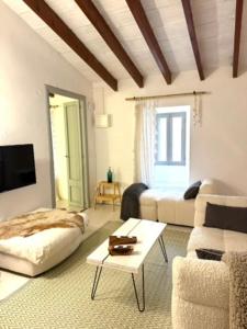 a living room with a couch and a table at Can PONÇ PARRA in Santanyi