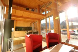 - une cuisine avec deux chaises rouges et une table dans l'établissement Chesa Randurel, à Pontresina