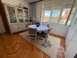 a dining room with a white table and chairs at Apartment TARGET in Cetinje