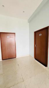 an empty room with two doors and a tile floor at Hotal Shivaay inn in Barāgaon