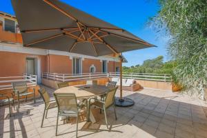 a patio with a table and chairs and an umbrella at Duplex d'exception face à la mer in Hyères +20 photos