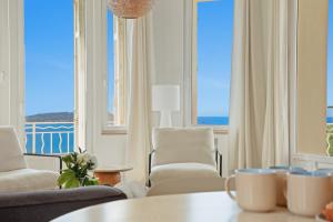 a living room with a table and chairs and a window at Duplex d'exception face à la mer in Hyères