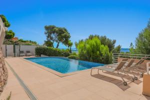 a swimming pool in a villa with lounge chairs at Duplex d'exception face à la mer in Hyères