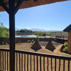 a view of a river from the porch of a house at DuckPond Lodge Cottage in Oudtshoorn