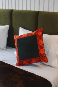 a red pillow sitting on top of a bed at The Himalayan Roots in Kulu +6 photos