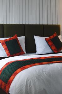 a bed with red and black pillows on it at The Himalayan Roots in Kulu