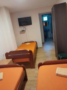 a room with two beds and a flat screen tv at Vila Ruška in Prčanj