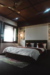 a bedroom with a large bed and a ceiling fan at The Himalayan Roots in Kulu