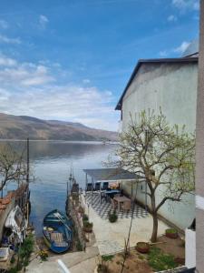 a building next to a body of water with a boat at villa stavri in Pogradec