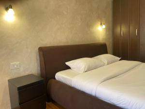 a bed with two pillows and a night stand in a room at Teuta Apartment in Tivat in Župa