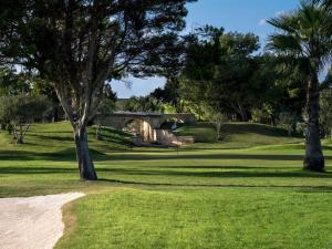a view of a golf course with a bridge and trees at Palazzino Nina Boutique Hotel in Qormi