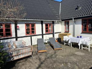 a patio with a table and chairs and a table and chairs and a building at Boots and Bikes B&B in Neksø