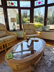 a living room with two chairs and a coffee table at Hilltown House - Room Only in Wexford