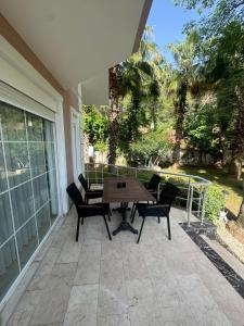 a patio with a wooden table and chairs at Amazonica MAGİC DREAM in Kemer