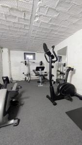 a gym with treadmills and exercise bikes in a room at FeWo Ertel in Hennigsdorf