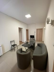 a living room with couches and a table and chairs at Atlas Hostel in Skopje