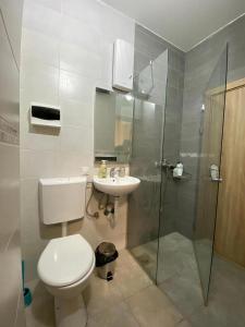 a bathroom with a toilet and a sink and a shower at Atlas Hostel in Skopje +46 photos