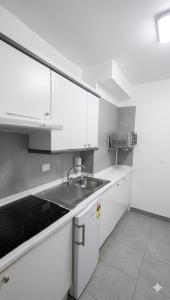 a kitchen with white cabinets and a sink at MC La Quinta in Santa Úrsula