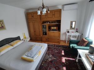 a bedroom with a bed and a living room at Šumarev konak in Valjevo