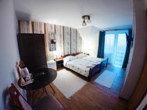 a bedroom with a bed and a desk and a table at Willa Anna Maria in Wysowa-Zdrój
