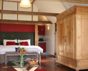 Knelle Dower Studio في Northiam: غرفة نوم بسرير كبير وطاولة عليها ورد