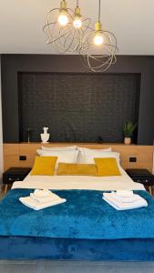 a bedroom with a large bed with two towels on it at Novus Luxury Apartment Free Parking in Craiova
