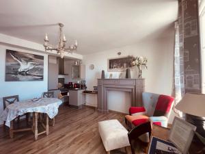a living room with a table and chairs and a kitchen at Villa des Sarcelles in Le Crotoy