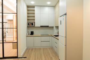 a kitchen with white cabinets and a refrigerator at Sapphire Residence in Khujand