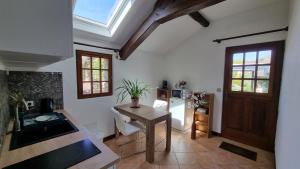 a kitchen with a table and a refrigerator at Les Maisons de Mélody in Houlbec-Cocherel