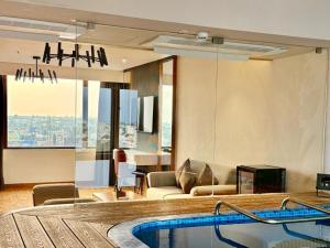 a hotel room with a swimming pool and a living room at SKI - Sivakavi Iconic in Pondicherry