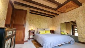 a bedroom with a large bed with yellow pillows at Les Maisons de Mélody in Houlbec-Cocherel +48 photos