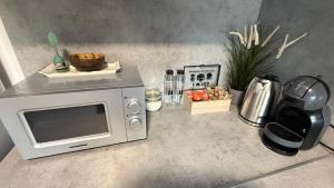 a kitchen counter with a microwave and a blender at Novus Luxury Apartment Free Parking in Craiova